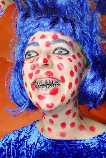 Zdjęcie pt. "KWAS issue3 Amok" - Agnieszka Sejud, Karolina Wojta Na zdjęciu: kobieca twarz w czerwone kropki, z niebieskimi włosami i srebrnymi zębami