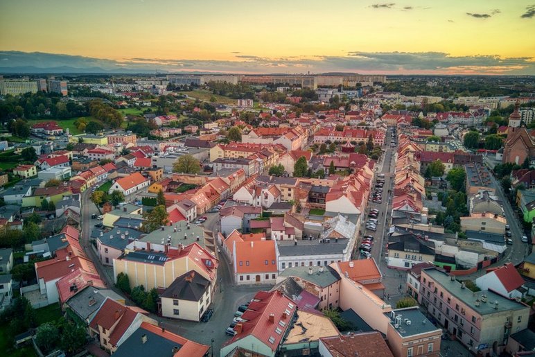 Widok z lotu ptaka na śródmieście Żor. Gęsta zabudowa z czerwonymi dachami i uliczki w kształcie elipsy. 