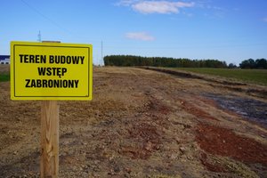 Na zdjęciu budowa drogi oraz znak ostrzegawczy o treści: Teren budowy wstęp wzbroniony