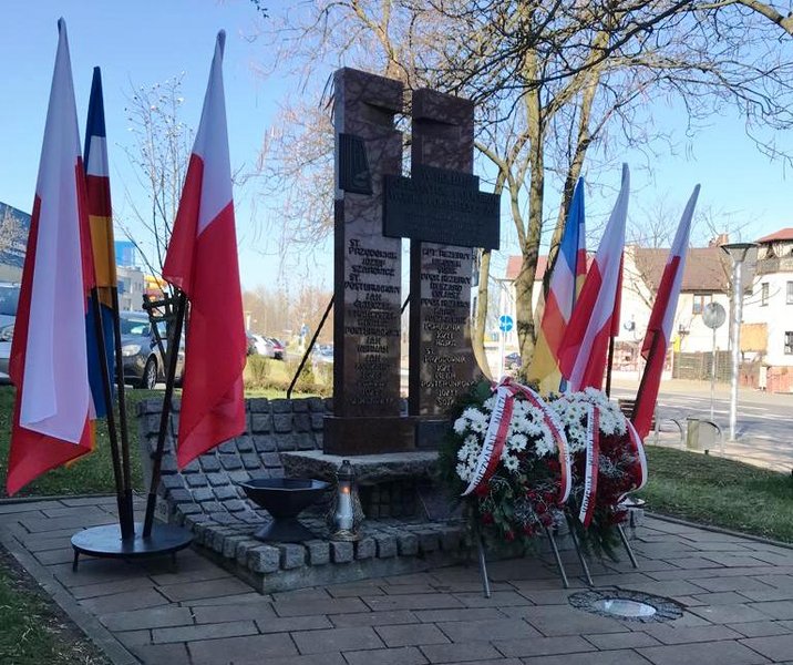 Pomnik Pomordowanych w Katyniu Policjantów i Oficerów Wojska Polskiego przyozdobiony kwiatami.