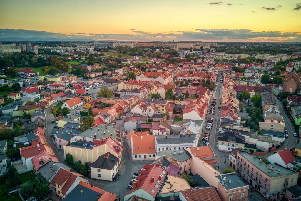 Widok z lotu ptaka na śródmieście Żor. Gęsta zabudowa z czerwonymi dachami i uliczki w kształcie elipsy. 